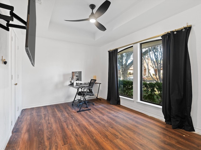 office area with dark hardwood / wood-style floors, ceiling fan, a wealth of natural light, and a tray ceiling