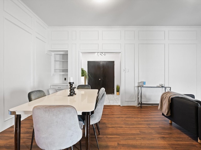 dining space with dark hardwood / wood-style flooring, built in features, and ornamental molding