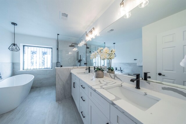 bathroom with tile patterned floors, vanity, tile walls, and plus walk in shower