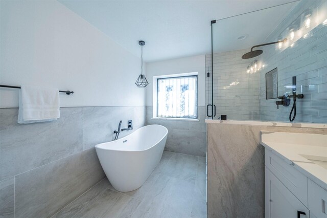 bathroom featuring vanity, separate shower and tub, and tile walls