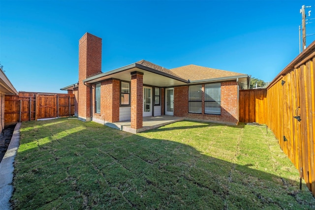 rear view of property featuring a patio area and a yard