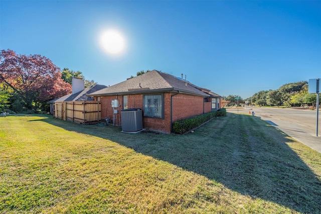 view of home's exterior with a lawn and central AC unit