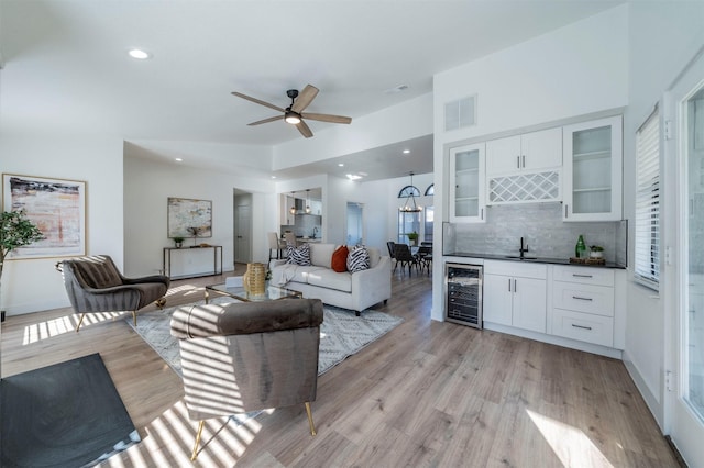 living room with indoor wet bar, beverage cooler, light wood-type flooring, and a wealth of natural light