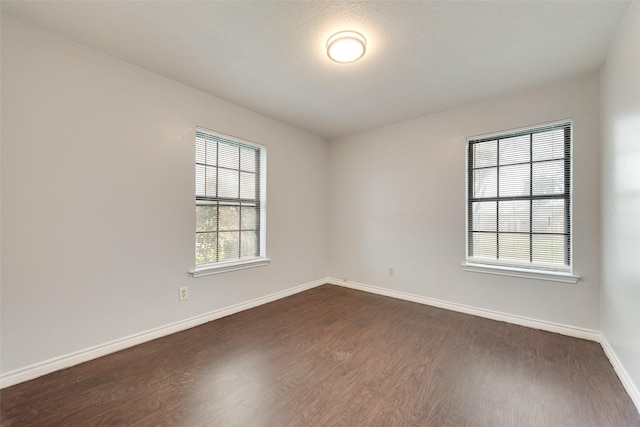 empty room with dark hardwood / wood-style flooring