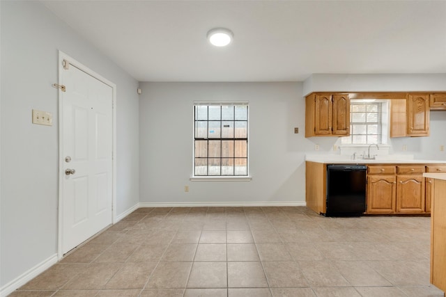 kitchen featuring light tile patterned floors, black dishwasher, and sink