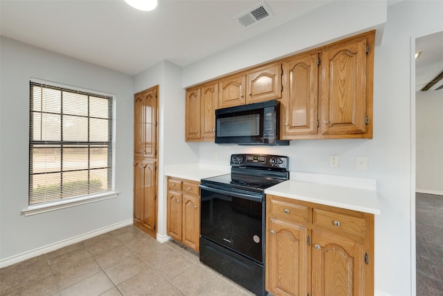 kitchen with light tile patterned flooring and black appliances