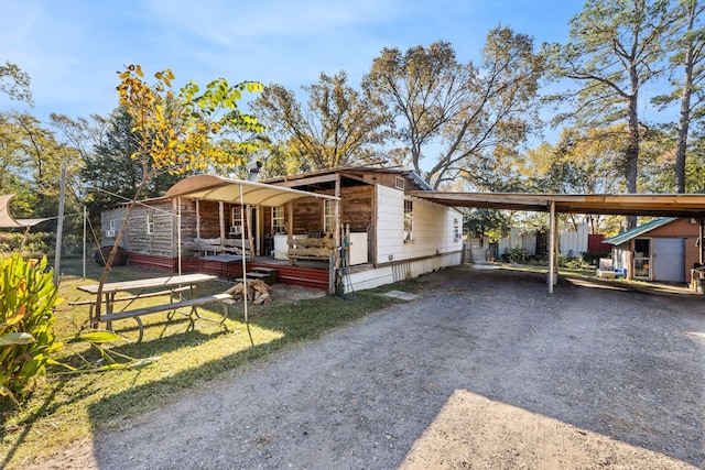 view of front of property featuring covered porch and a carport