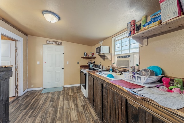 kitchen featuring dark brown cabinetry, sink, dark hardwood / wood-style floors, lofted ceiling, and white appliances