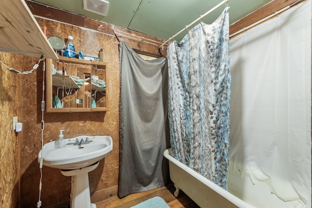 bathroom with shower / bath combo with shower curtain and sink