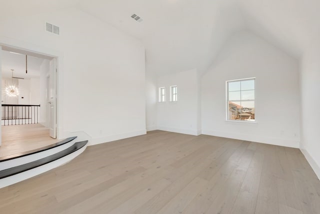 unfurnished living room with high vaulted ceiling and light hardwood / wood-style floors