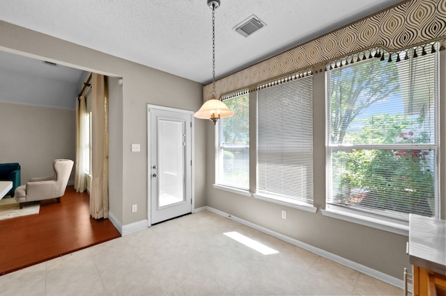 interior space featuring a healthy amount of sunlight and a textured ceiling