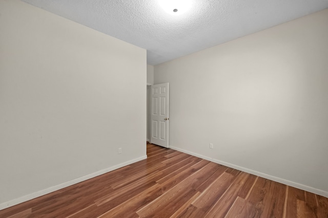 spare room with wood-type flooring and a textured ceiling