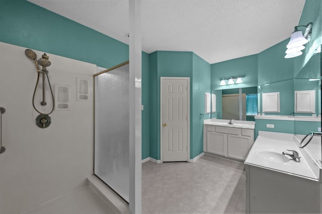 bathroom with a textured ceiling, vanity, and an enclosed shower