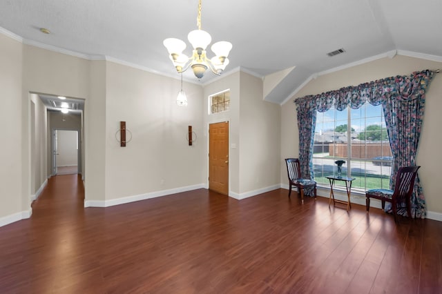 interior space featuring lofted ceiling, dark hardwood / wood-style flooring, an inviting chandelier, and crown molding