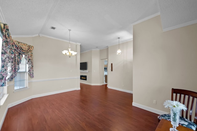 interior space with a textured ceiling, crown molding, dark hardwood / wood-style flooring, and lofted ceiling