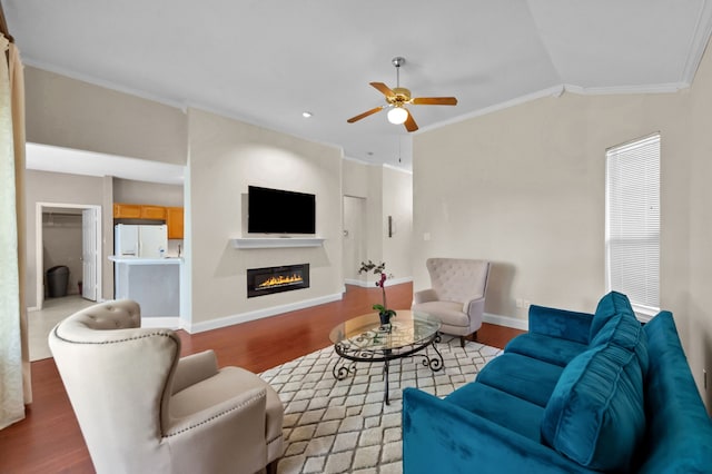 living room featuring ceiling fan, vaulted ceiling, ornamental molding, and light hardwood / wood-style flooring