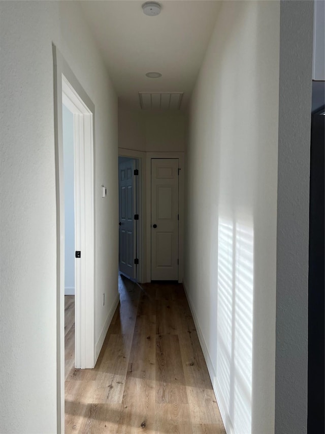 corridor with light hardwood / wood-style floors