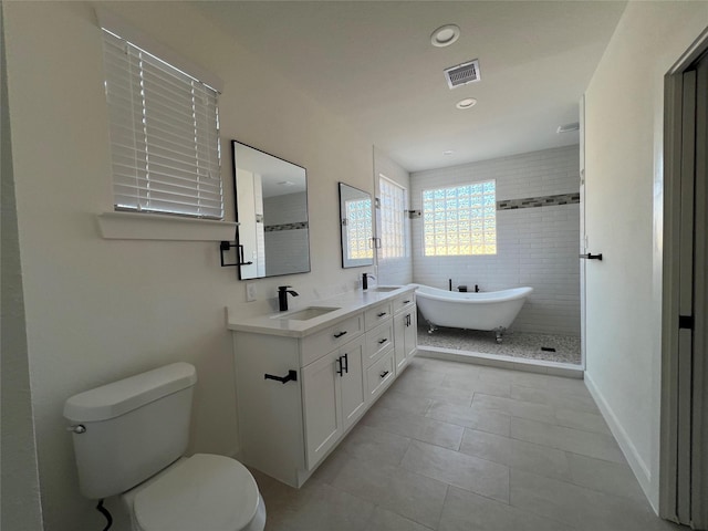 bathroom featuring a tub to relax in, tile patterned flooring, vanity, and toilet