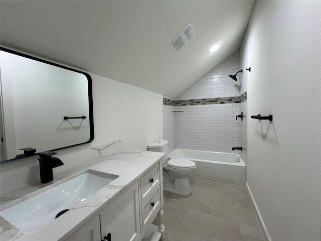 full bathroom with vanity, lofted ceiling, tiled shower / bath, toilet, and a textured ceiling