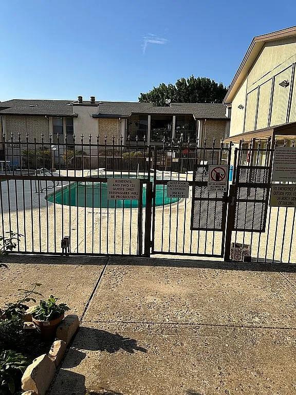 view of gate featuring a community pool