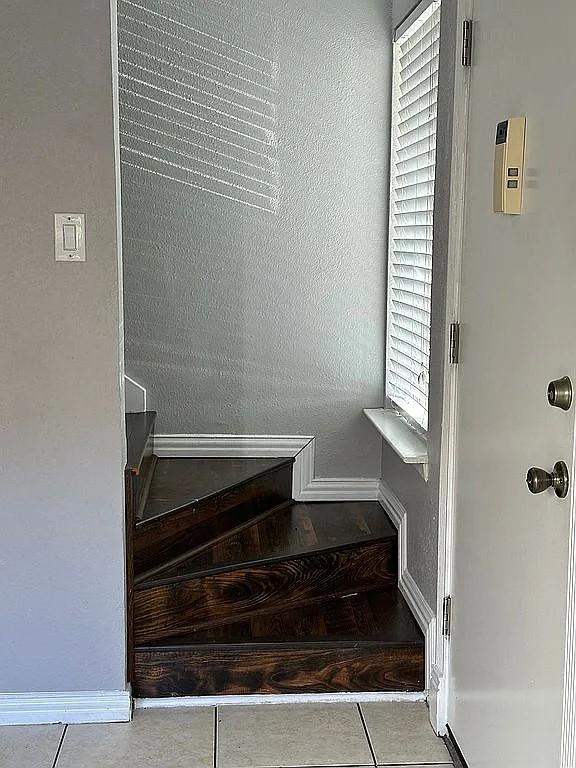 stairway with tile patterned floors