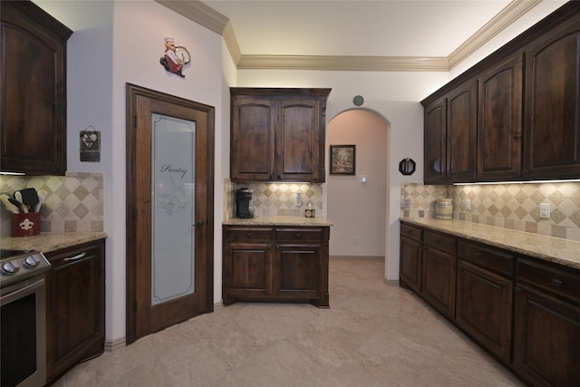 kitchen with electric range, decorative backsplash, dark brown cabinetry, and crown molding