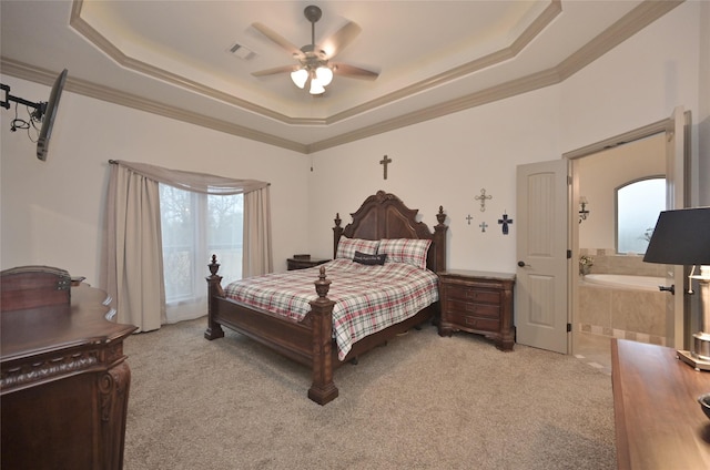 bedroom featuring a tray ceiling, connected bathroom, ceiling fan, and light carpet