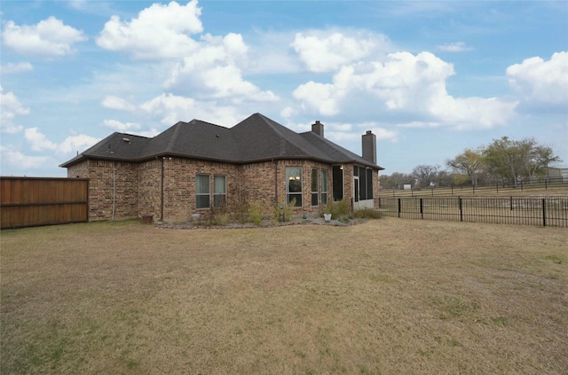 rear view of house featuring a lawn