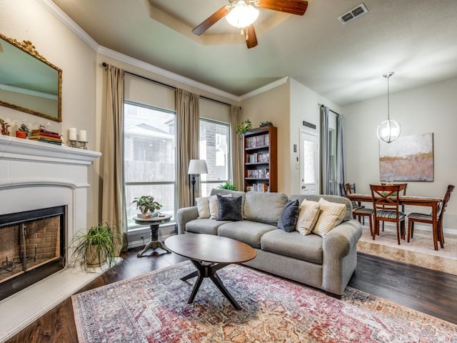 living room with ceiling fan, crown molding, and dark hardwood / wood-style flooring