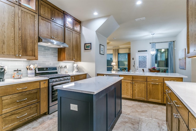 3308 Estacado Dr, Denton, TX 76210 - kitchen with a peninsula, under cabinet range hood, light countertops, tasteful backsplash, and gas stove