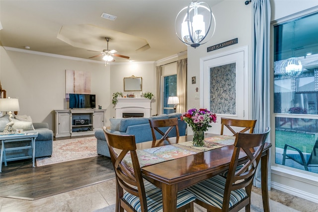 3308 Estacado Dr, Denton, TX 76210 - dining space with a tray ceiling, crown molding, a fireplace, and ceiling fan with notable chandelier