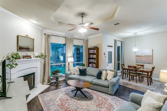 3308 Estacado Dr, Denton, TX 76210 - living room with wood finished floors, ornamental molding, visible vents, a ceiling fan, and a glass covered fireplace