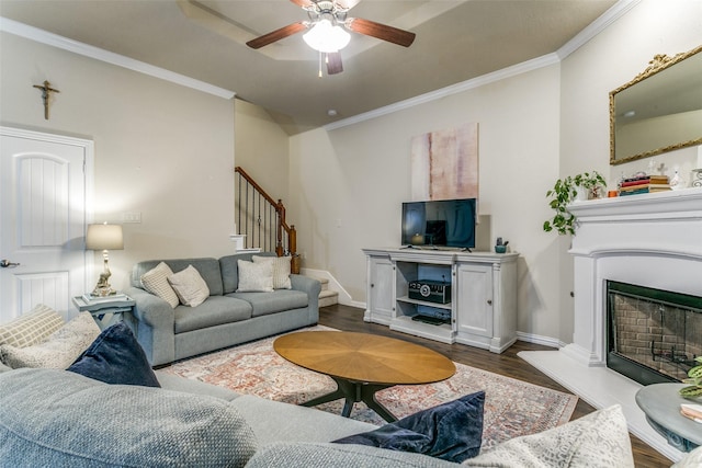 3308 Estacado Dr, Denton, TX 76210 - living room featuring crown molding, stairway, dark wood-style flooring, ceiling fan, and a fireplace with raised hearth