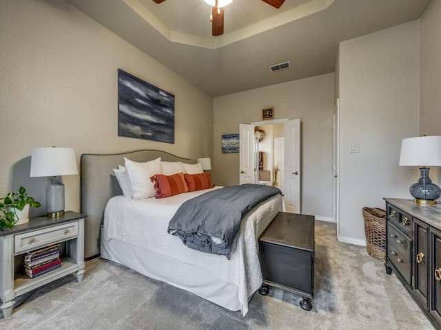 bedroom with carpet flooring, a tray ceiling, and ceiling fan