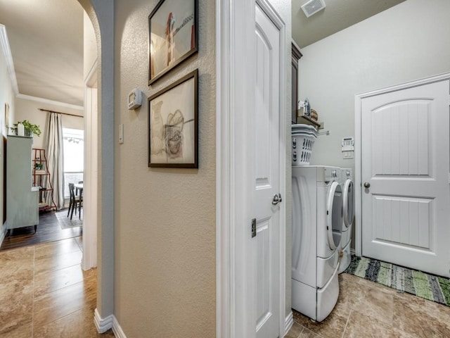 laundry area with washer and clothes dryer and ornamental molding