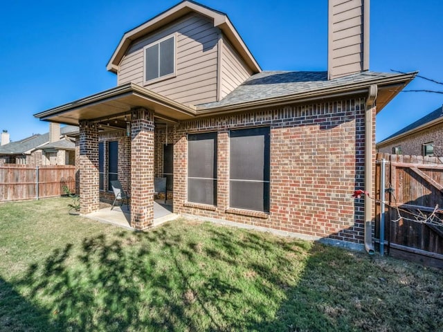 back of property featuring a lawn and a patio area