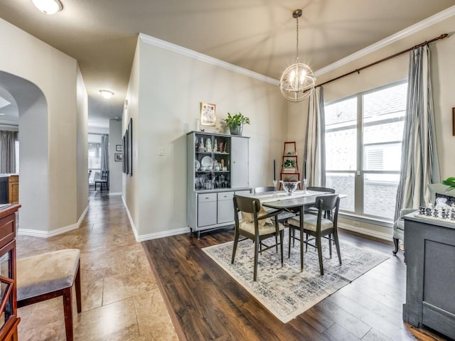 dining area featuring a chandelier, dark wood-type flooring, and ornamental molding