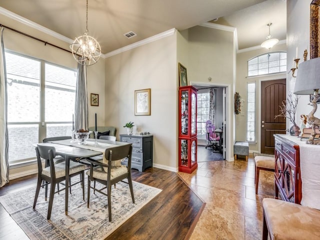 dining space featuring crown molding, plenty of natural light, and a notable chandelier