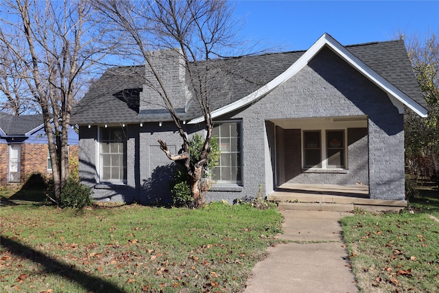 view of front of property featuring a front yard and roof with shingles