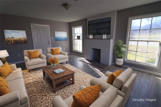 living area with baseboards, a fireplace with raised hearth, and wood finished floors