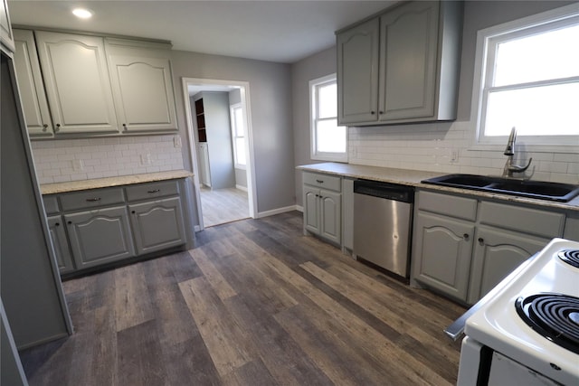 kitchen featuring white electric range oven, dark wood finished floors, gray cabinetry, a sink, and stainless steel dishwasher