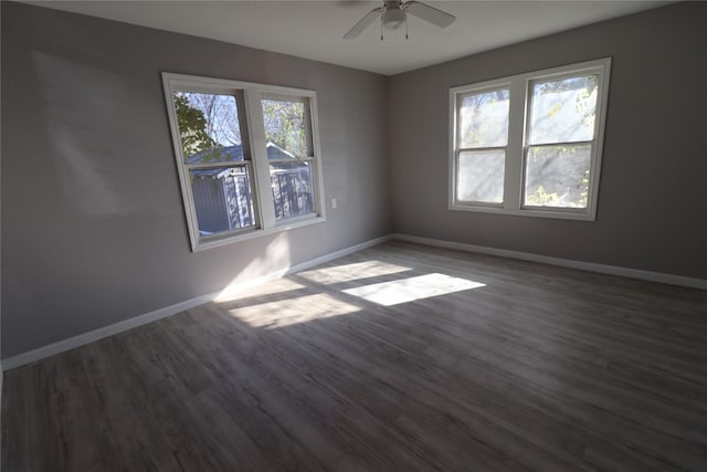 spare room with dark wood-type flooring, baseboards, and ceiling fan