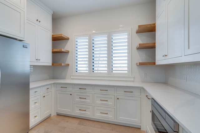 kitchen featuring white cabinetry, appliances with stainless steel finishes, and light stone counters