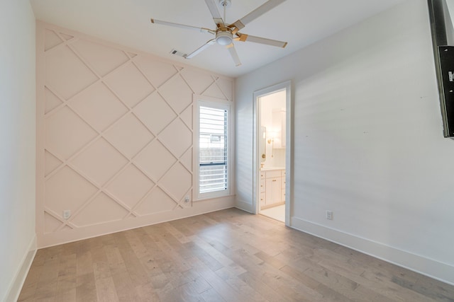 empty room with ceiling fan and light hardwood / wood-style floors