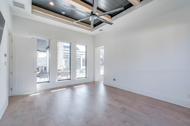 unfurnished room with a raised ceiling, ceiling fan, wood ceiling, and light hardwood / wood-style floors