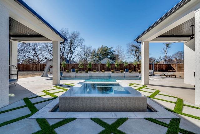 exterior space featuring an in ground hot tub and a patio