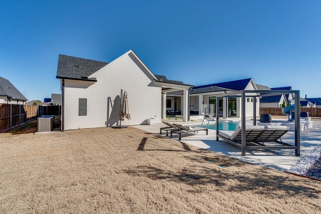 back of house with a fenced in pool and a patio area