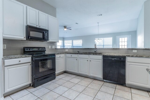 kitchen featuring tasteful backsplash, sink, white cabinets, black appliances, and light stone countertops