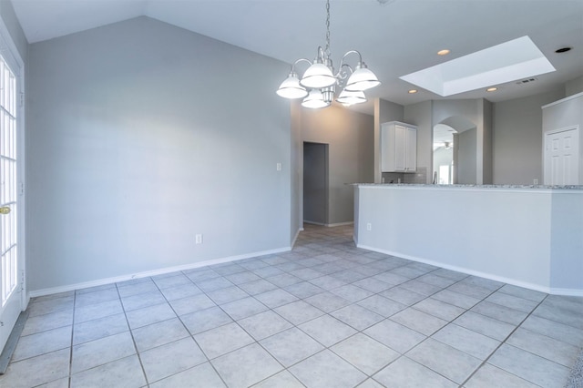 unfurnished room with vaulted ceiling with skylight and a chandelier