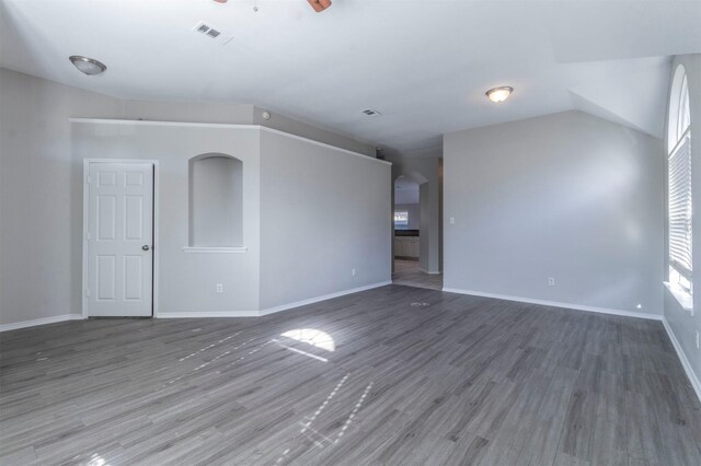 unfurnished living room featuring dark wood-type flooring and ceiling fan